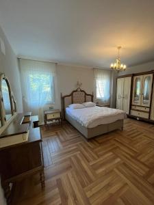 um quarto com uma cama e piso em madeira em Bahçeli villa dairesi em Trabzon