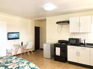 um quarto com uma cama e uma cozinha com um fogão em LouieVille Studio Apartment em Lusaka