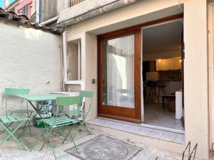 a green table and chairs sitting outside of a house at Île de Porquerolles, studio charmant, sans wifi in Porquerolles