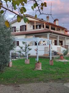 a large white house with an arch in the yard at Il Nido in Fiano Romano