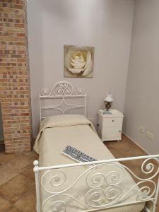 a white bed in a room with a flower picture on the wall at Il Nido in Fiano Romano