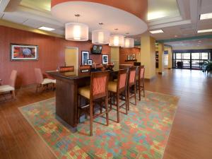 a large room with a bar with chairs and a rug at Hampton Inn Martinsville in Martinsville