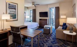 Homewood Suites By Hilton New Orleans French Quarter في نيو أورلينز: غرفة الفندق بسرير ومكتب واريكة