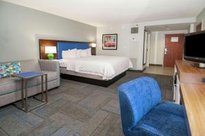 a hotel room with a bed and a couch at Hampton Inn Metairie in Metairie