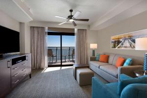 sala de estar con sofá y TV de pantalla plana en Hilton Grand Vacations Club Anderson Ocean Myrtle Beach en Myrtle Beach
