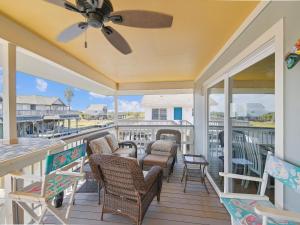 a porch with chairs and a ceiling fan at Celestial Dreams in Galveston