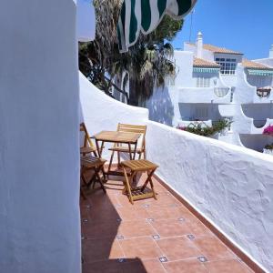 a patio with chairs and a table on a wall at Apartamento Luz in Chiclana de la Frontera
