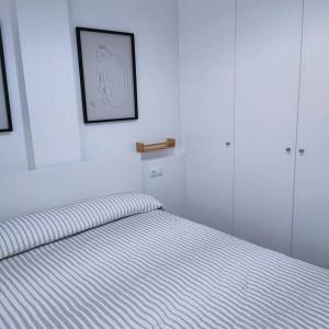 a bedroom with a bed with a striped blanket at Apartamento Luz in Chiclana de la Frontera