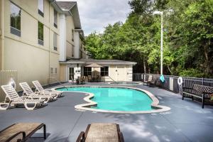 a swimming pool with lounge chairs next to a building at Hampton Inn Murrells Inlet/Myrtle Beach Area in Myrtle Beach