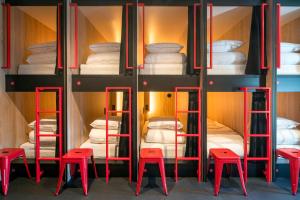 a room with four red stools and bunk beds at City Trip Hostels Amsterdam-Zaandam in Zaandam +59 photos