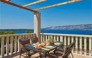 a table and chairs on a balcony with a view of the water at Villa 4 Mala Rudina in Rudina
