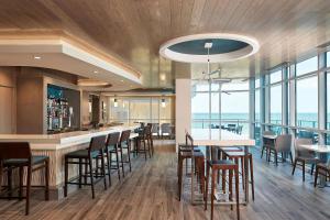 um restaurante com um bar com cadeiras e mesas em Hilton Grand Vacations Club Ocean Enclave Myrtle Beach em Myrtle Beach