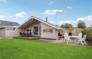 een achtertuin met een tafel en stoelen en een huis bij 2 Bedroom Lovely Home In Otterup in Otterup