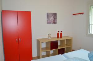 ブルンネンにあるFerienhaus Stockliの赤いキャビネットと木製の棚が備わるベッドルーム