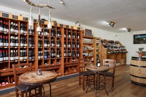 uma sala de degustação de vinhos com duas mesas e prateleiras de garrafas de vinho em Vindumi em Kirkel