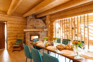 a dining room with a long table and a fireplace at Fox Wood House in Ciobotani