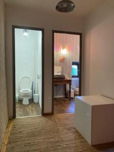 a room with a bathroom with a toilet and a desk at Maison en pierre dans le Sidobre in Le Bez