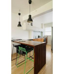 コペンハーゲンにあるApartmentInCopenhagen Apartment 139のキッチン(木製テーブル、緑の椅子2脚付)