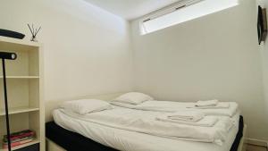 a room with a bed with white sheets and a window at ApartmentInCopenhagen Apartment 139 in Copenhagen