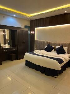 a bedroom with a large bed and a bathroom at Rekaz Aparthotel in Mecca