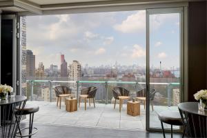 balcone con tavoli, sedie e vista sulla città di Hampton Inn Brooklyn Downtown a Brooklyn