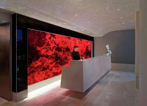 a man sitting at a counter in front of a red painting at Hilton Club The Quin New York in New York