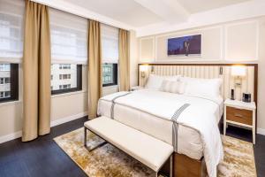 a bedroom with a large bed and two windows at Hilton Club The Quin New York in New York +37 photos