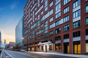 a tall red brick building on a city street at Hilton Brooklyn New York in Brooklyn