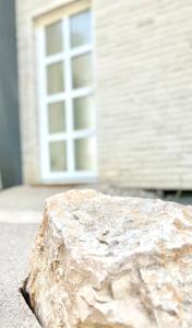 a rock sitting in front of a building with a window at Bungalow Dream Oasis Dobra Voda in Dobra Voda