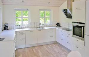 eine weiße Küche mit weißen Schränken und Geräten in der Unterkunft 4 Bedroom Gorgeous Home In Glesborg in Fjellerup