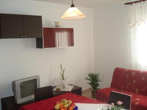 a living room with a table and a television at Apartments Buzleta in Fažana