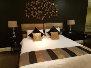 a bedroom with a large white bed with pillows at The Keep Boutique Hotel in Yeovil
