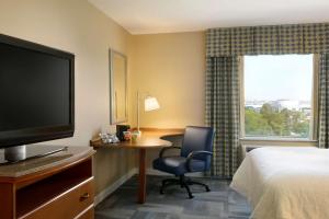 a hotel room with a desk and a bed and a television at Hampton Inn New York - LaGuardia Airport in Queens