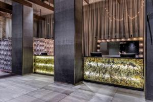 a lobby with a bar with a chandelier at Doubletree By Hilton New York Times Square West in New York