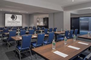 une salle de conférence avec des tables en bois et des chaises bleues dans l'établissement Doubletree By Hilton New York Times Square West, à New York