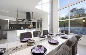 ein Esszimmer mit einem großen weißen Tisch und Stühlen in der Unterkunft Nice Home In Bilice With Outdoor Swimming Pool in Bilice