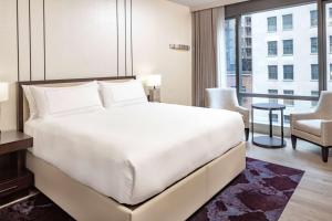 a bedroom with a large white bed and a large window at Hilton Club West 57th Street New York in New York