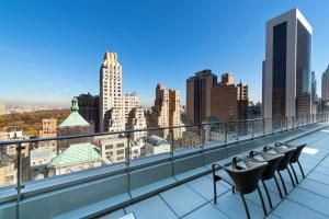 einen Balkon mit Stühlen und Stadtblick in der Unterkunft Hilton Club West 57th Street New York in New York