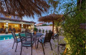 eine Terrasse mit Tisch und Stühlen neben einem Pool in der Unterkunft Villa Karmen in Zaton