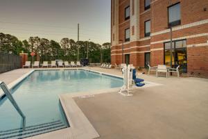 a large swimming pool in front of a brick building at Hampton Inn Sneads Ferry Topsail Beach in Sneads Ferry
