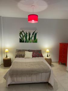 a bedroom with a large bed and a pink light at Maison Rouge Puerto Madryn in Puerto Madryn
