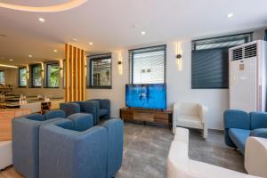 DIAMOND luxury Hotel في أنطاليا: غرفة انتظار مع كراسي زرقاء وتلفزيون بشاشة مسطحة