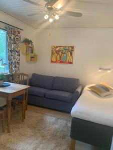 a living room with a blue couch and a table at Mysigt boende i Åhus med egen ingång, terass, wifi, tvättmaskin & parkering! in Åhus
