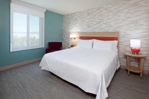 Un dormitorio con una gran cama blanca y una ventana en Home2 Suites By Hilton Alameda Oakland Airport, en Alameda