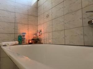 y baño con bañera blanca y azulejos blancos. en The Lake House -Trichonida Lake, en Marathiás