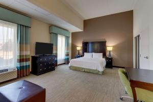 a hotel room with a bed and a flat screen tv at Hampton Inn and Suites Swansboro Near Camp Lejeune in Swansboro