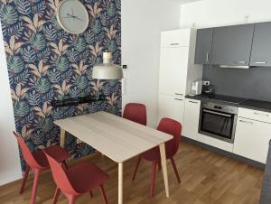 a kitchen with a table and chairs and a clock on a wall at Lend City Apartment self-check-in in Graz