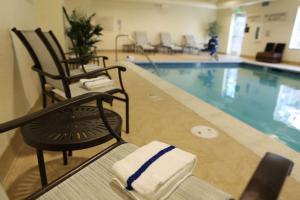 a pool with two chairs next to a swimming pool at Hampton Inn Union City in Union City