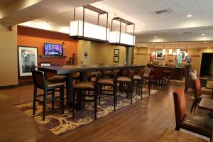a restaurant with a long bar with chairs in a room at Hampton Inn Union City in Union City