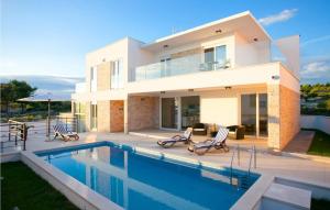 a house with a swimming pool in front of it at Villa Crystal Blue in Rogoznica